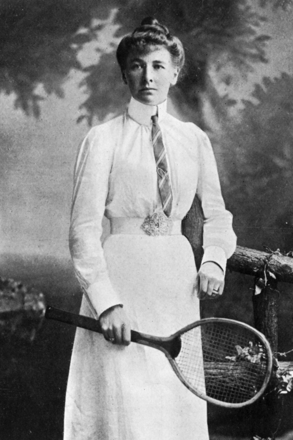 A black and white photo of Charlotte Sterry holding her tennis racket