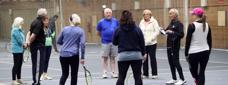 Tennis4RAD group participants on court for a tennis-based fitness class.