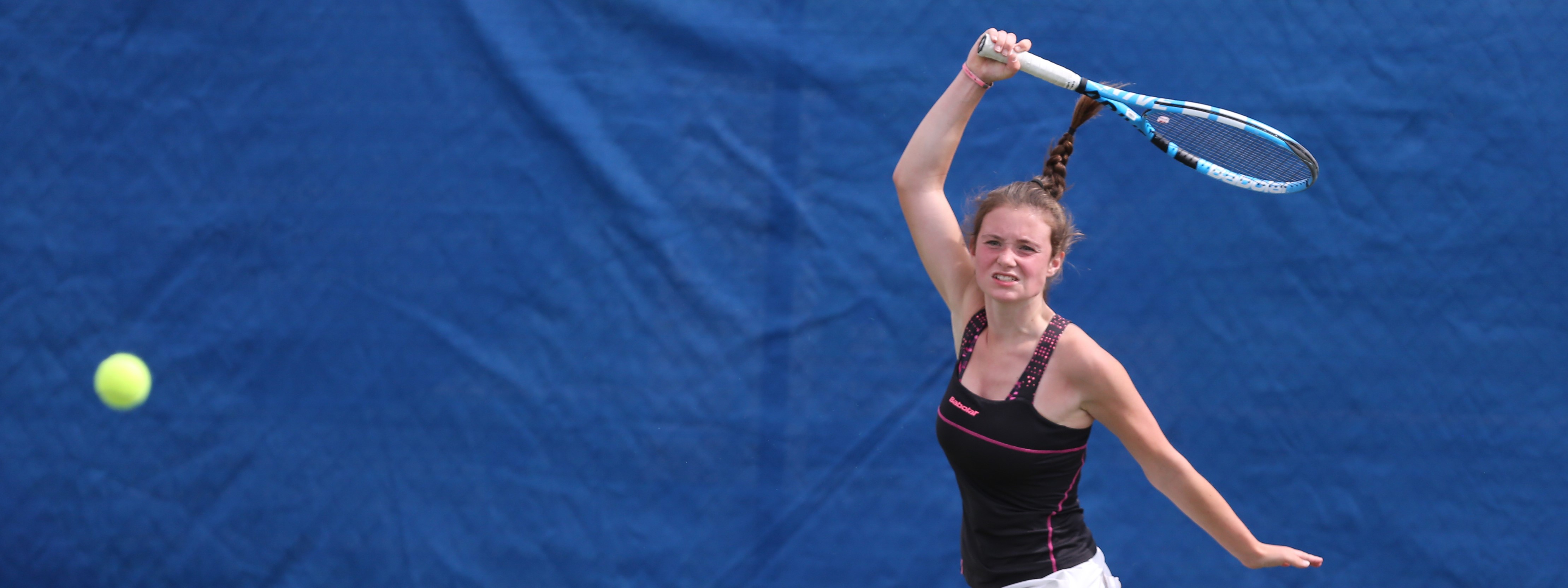 A girl hitting a forehand shot on court
