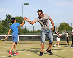 Adult and child high five during a tennis session